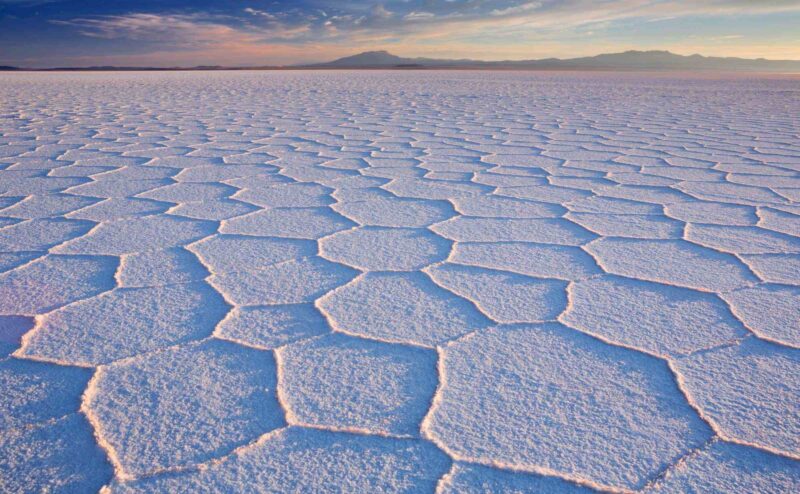 Salt flat Salar de Uyuni in Bolivia at sunrise sunrise, salar de uyuni, bolivia, desert, altiplano, salt flat, south america, uyuni, hexagon, salt lake, dawn, remote, barren, arid, photography, photo, image, horizontal, colour, color, outdoors, nature, scenics, scenery, landscape, extreme terrain, wilderness, dry, playa, mountains, solitude, horizon, horizon over land, famous place, travel destination, morning, sunlight, clouds, latin america, no people, nobody, salt, plain The world’s largest salt flat, Salar de Uyuni in Bolivia, photographed at sunrise.