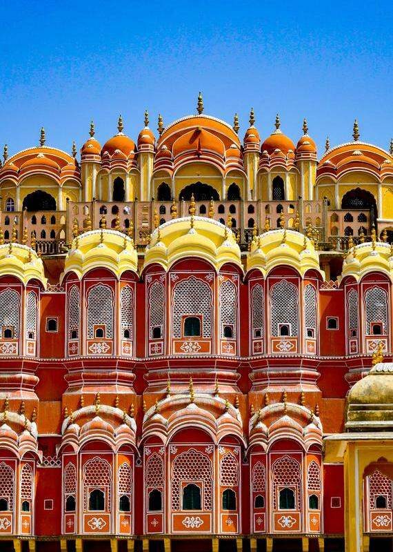 Close-up of the ornate, multi-story red and yellow sandstone facade of Hawa Mahal with its distinct honeycombed windows.