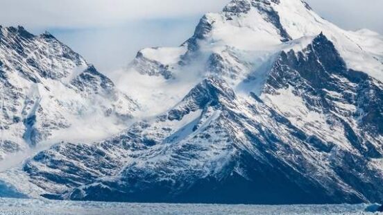 A tour boat passes by in front of the massive Perito Moreno Glacier at El Calafate, Argentina