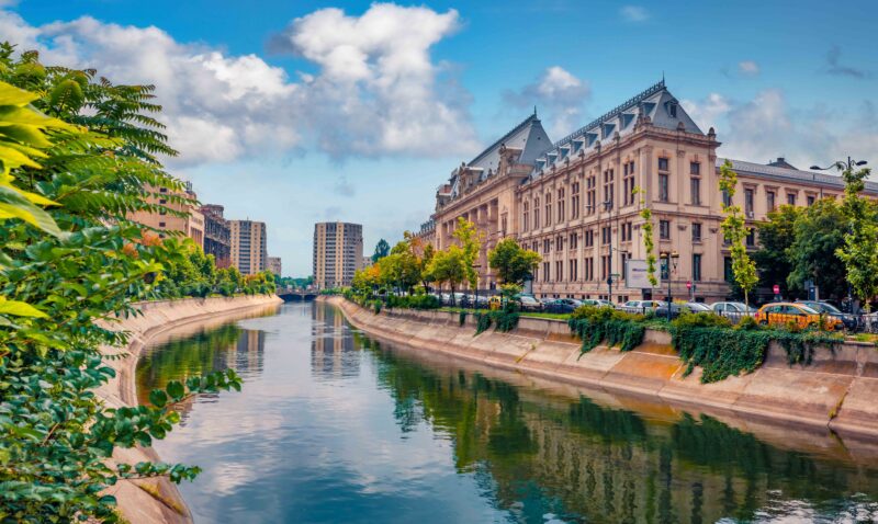 Wonderful morning cityscape of Bucharest city – capital of Romania, Europe. Spectacular summer view of Court of Appeal Building on tne Dambovita river. Traveling concept background.