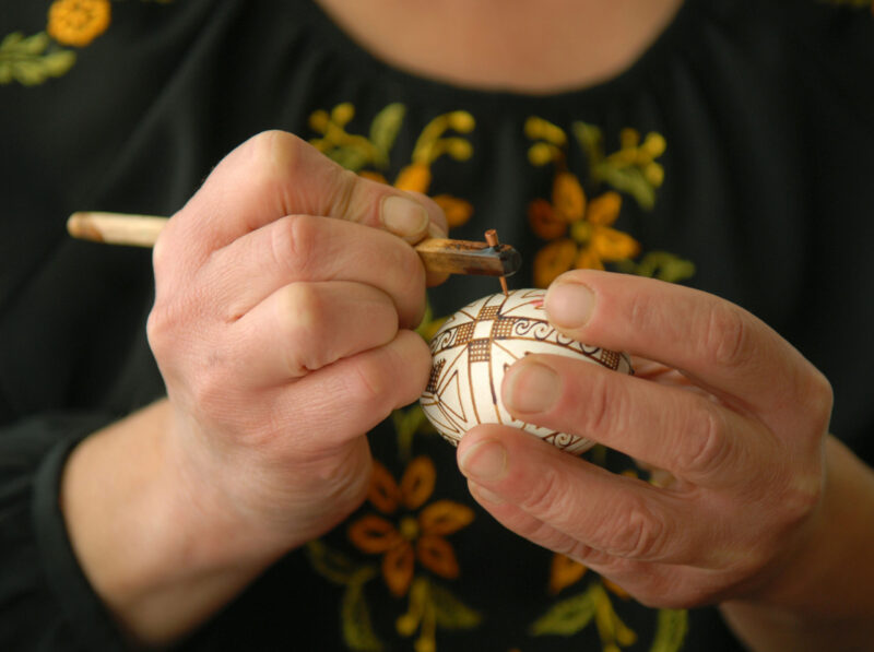 Craftswoman decorates egg before Easter with help of pisachok. Kolomyia.