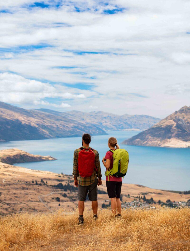 Landscape Caucasian male and female New Zealand adventure hikers on their travel trekking vacation near scenic Lake Wakatipu Queenstown The Remarkables Otago