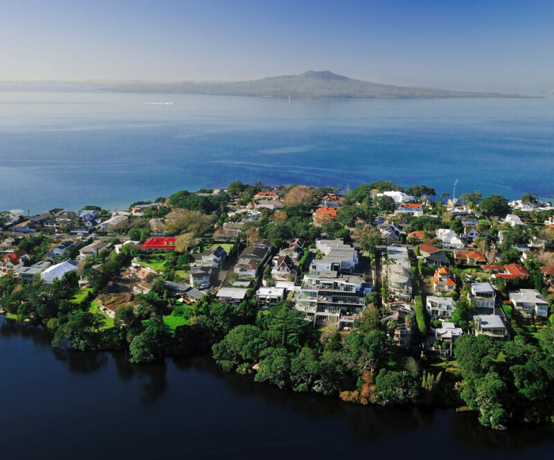 Rangitoto Island in the distance with the suburb of Milford in the North Shore in the foreground. Shot over Lake Pupuke. Auckland, New Zealand