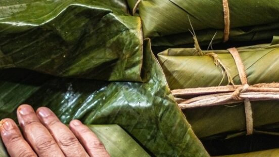 A person preparing tamales, traditional Colombian food