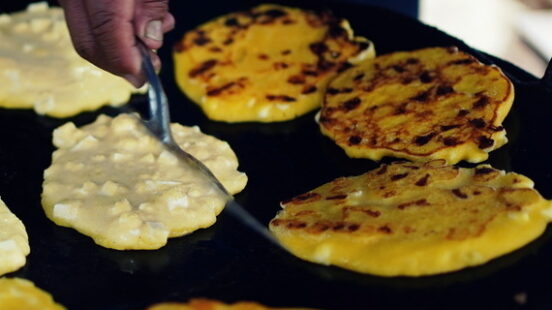 Freshly prepared arepas with cheese on a street stall