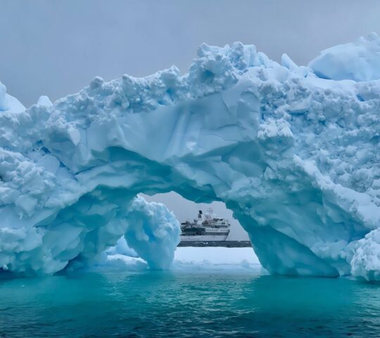 An arch of ice with grey skies in Antarctica