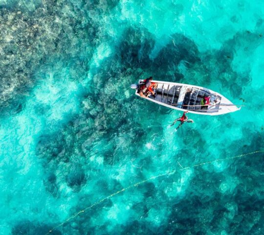 A boat floats on the turquoise waters that surround Mauritius