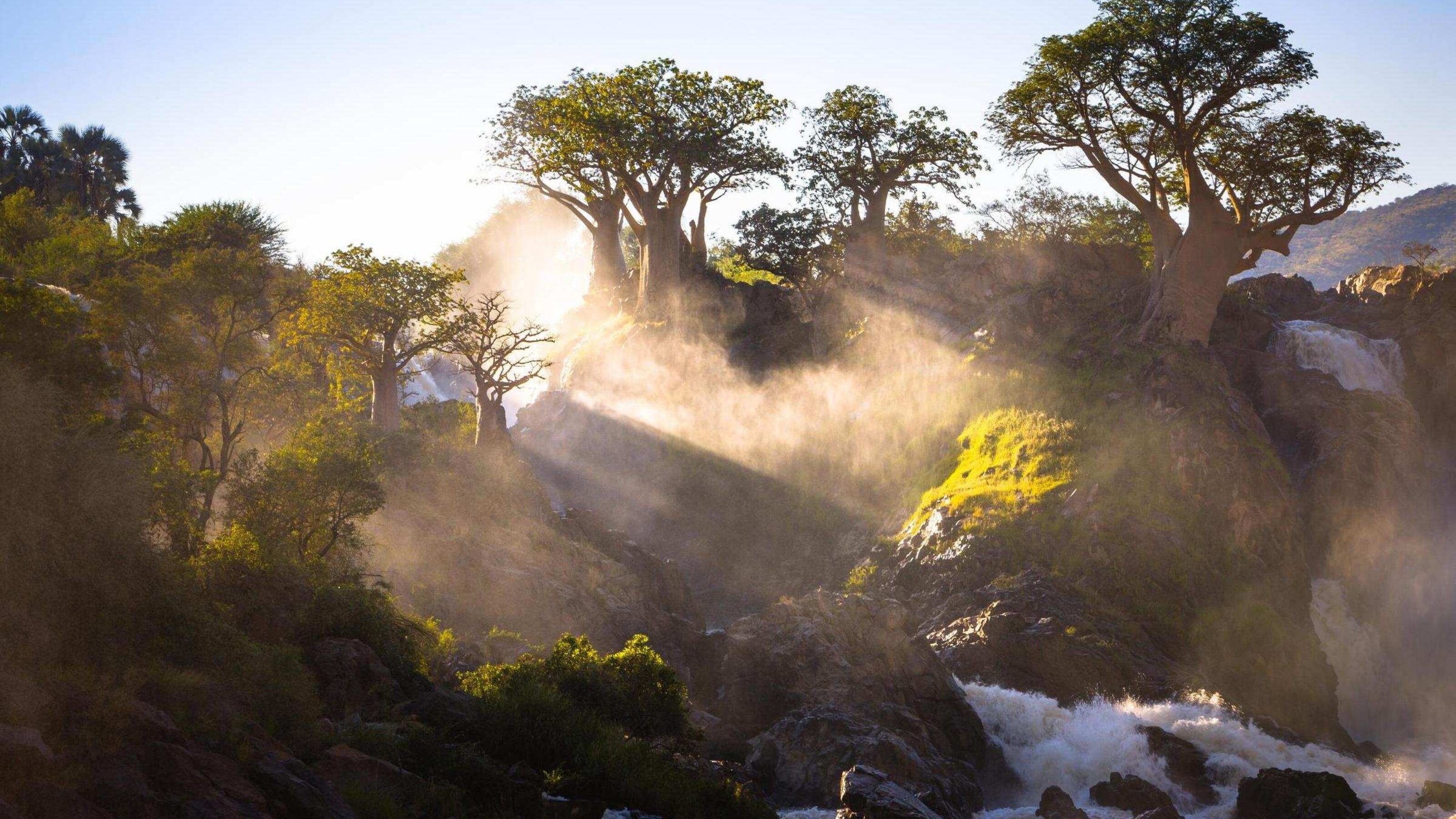 Misty sunrise over Epupa Falls near the Kunene River, Namibia.