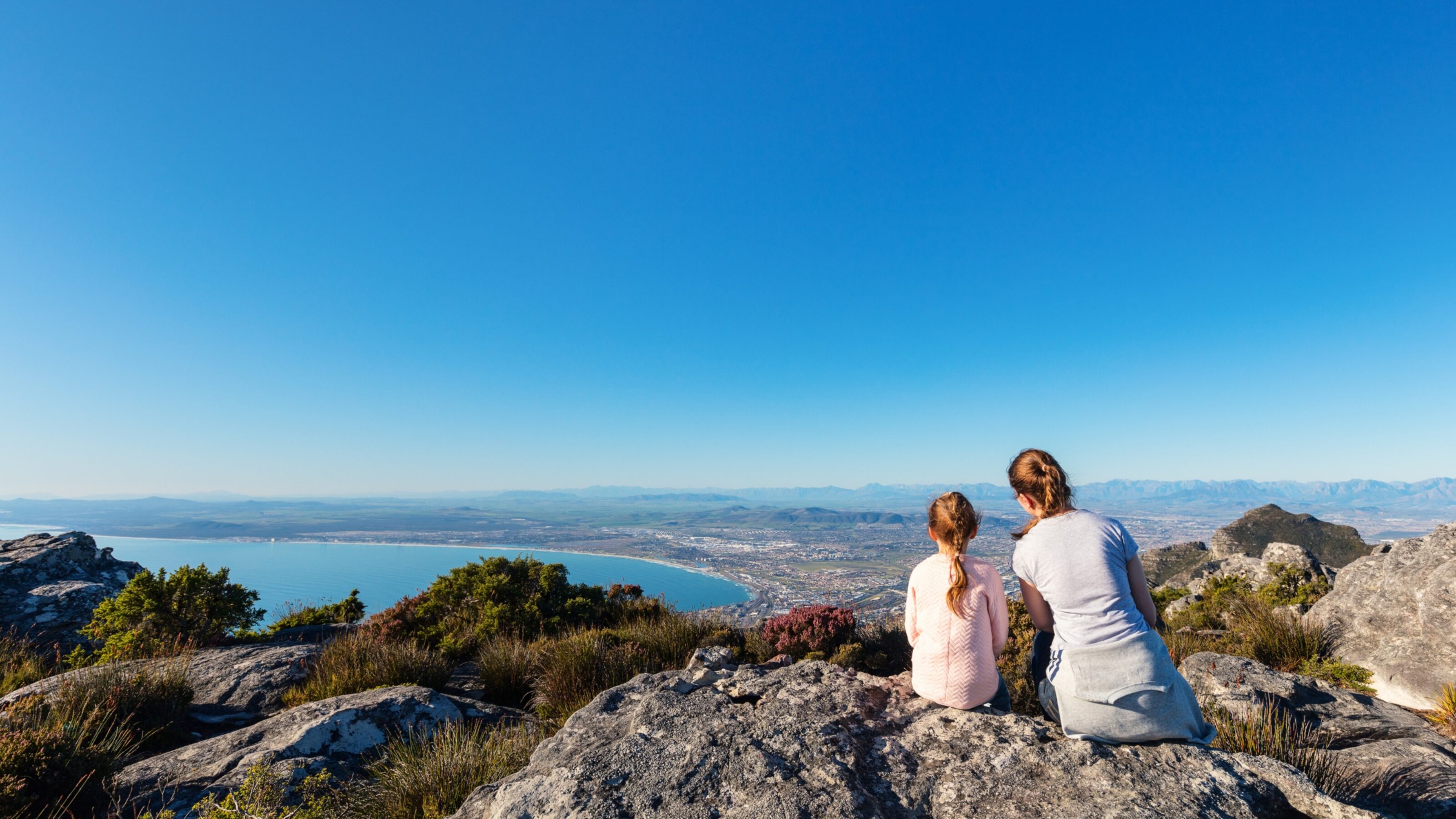 A girl and her mother sat at a viewpoint in Cape Town, South Africa.