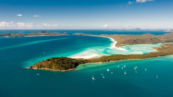Aerial view of white sands swirling through clear waters at Hill Inlet – Whitsundays, Australia.