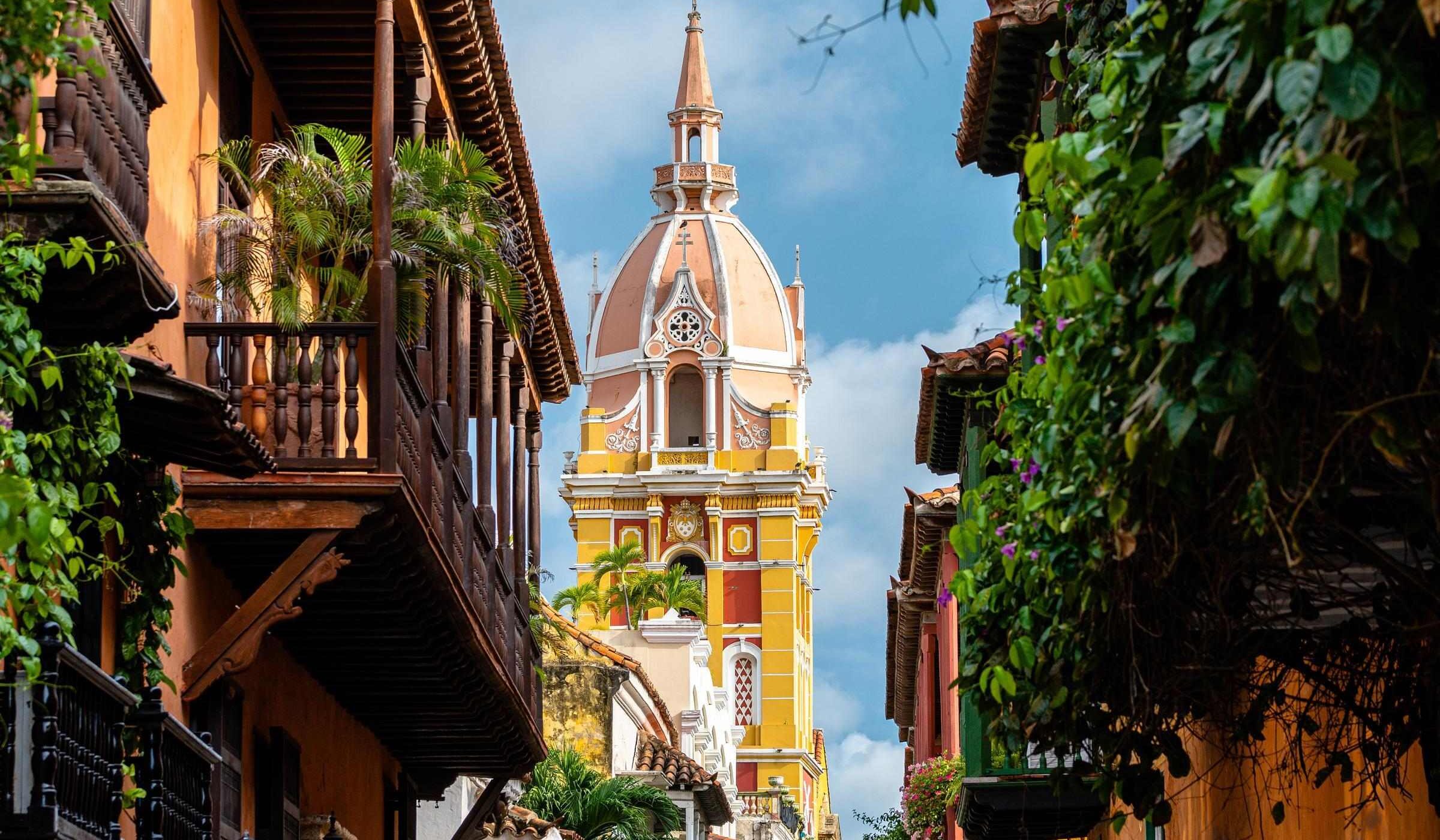 The tall yellow spire of a church in Cartagena, Colombia
