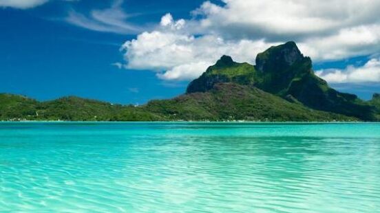 Turquoise water with green mountains in the background in French Polynesia