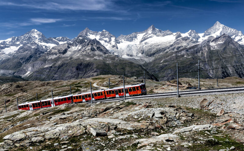 Mountain train en route between Gornergrat and Zermatt with Weisshorn mountain range in background.