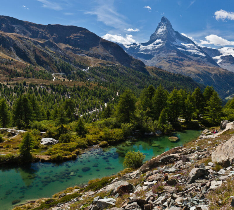 View of the Matterhorn in Zermatt, Switzerland on a clear summer day with an emerald-colored mountain lake (the Grindjisee) visible in the foreground.