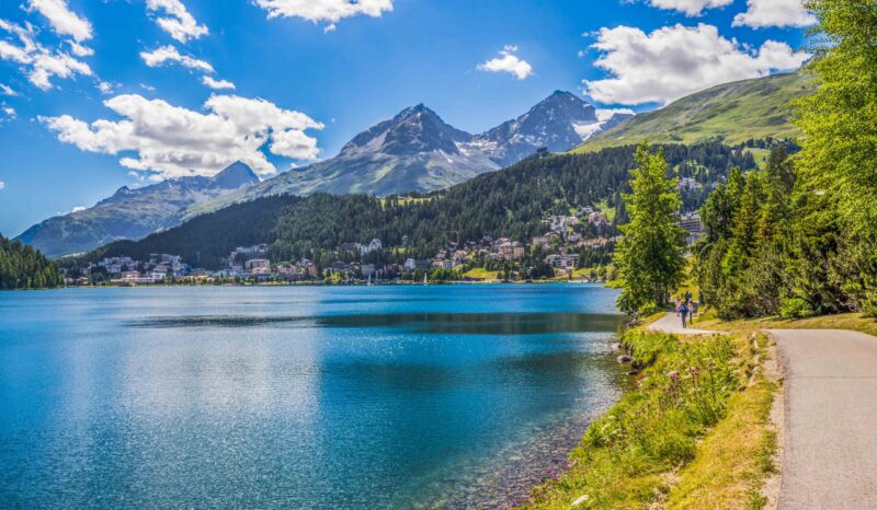 People walking along Sankt Moritzersee. St. Moritz (German – Sankt Moritz; Italian – San Maurizio) is a high Alpine resort in the Engadine, Graubunden, Switzerland.