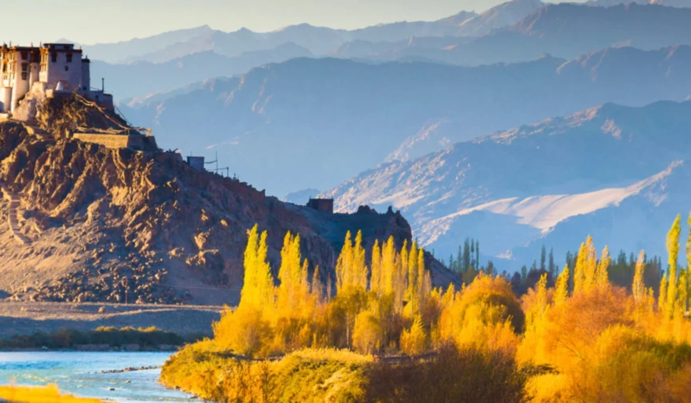 A landscape view of Ladakh, including mountains and buildings in the distance.