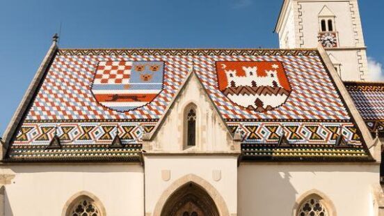 St. Markx27;s Church showing its famous colorful tiled roof with heraldic shields and a white stone exterior.