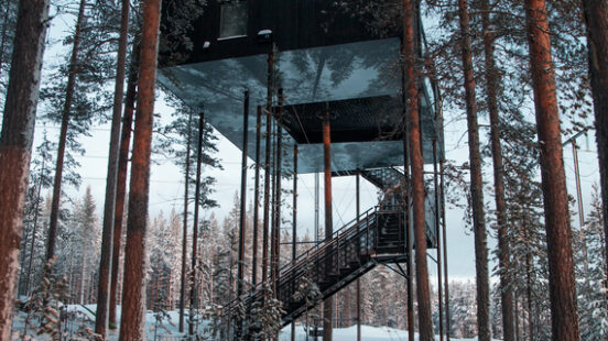 A treehouse on stilts in the snow at Treehotel, Sweden