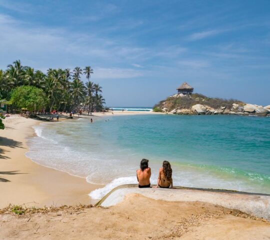 A couple enjoy one of Tayrona's sandy, palm fringed beaches