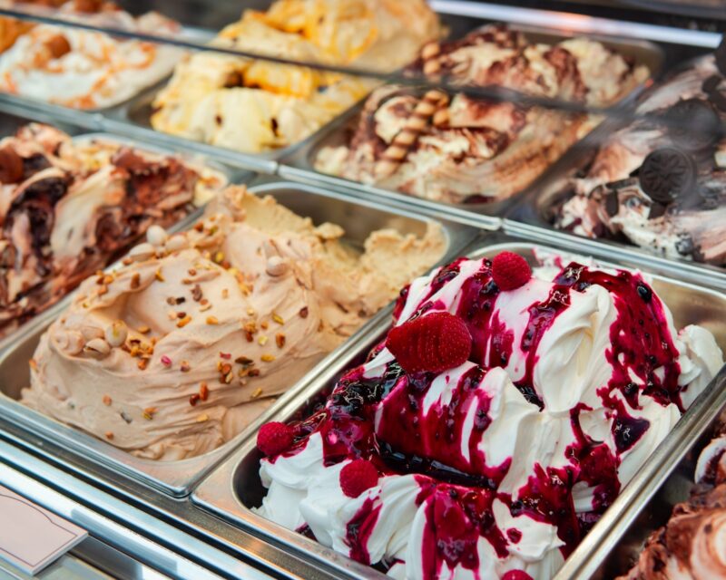 Freshly churned artisan gelato displayed in stainless steel trays at an authentic Italian gelateria.