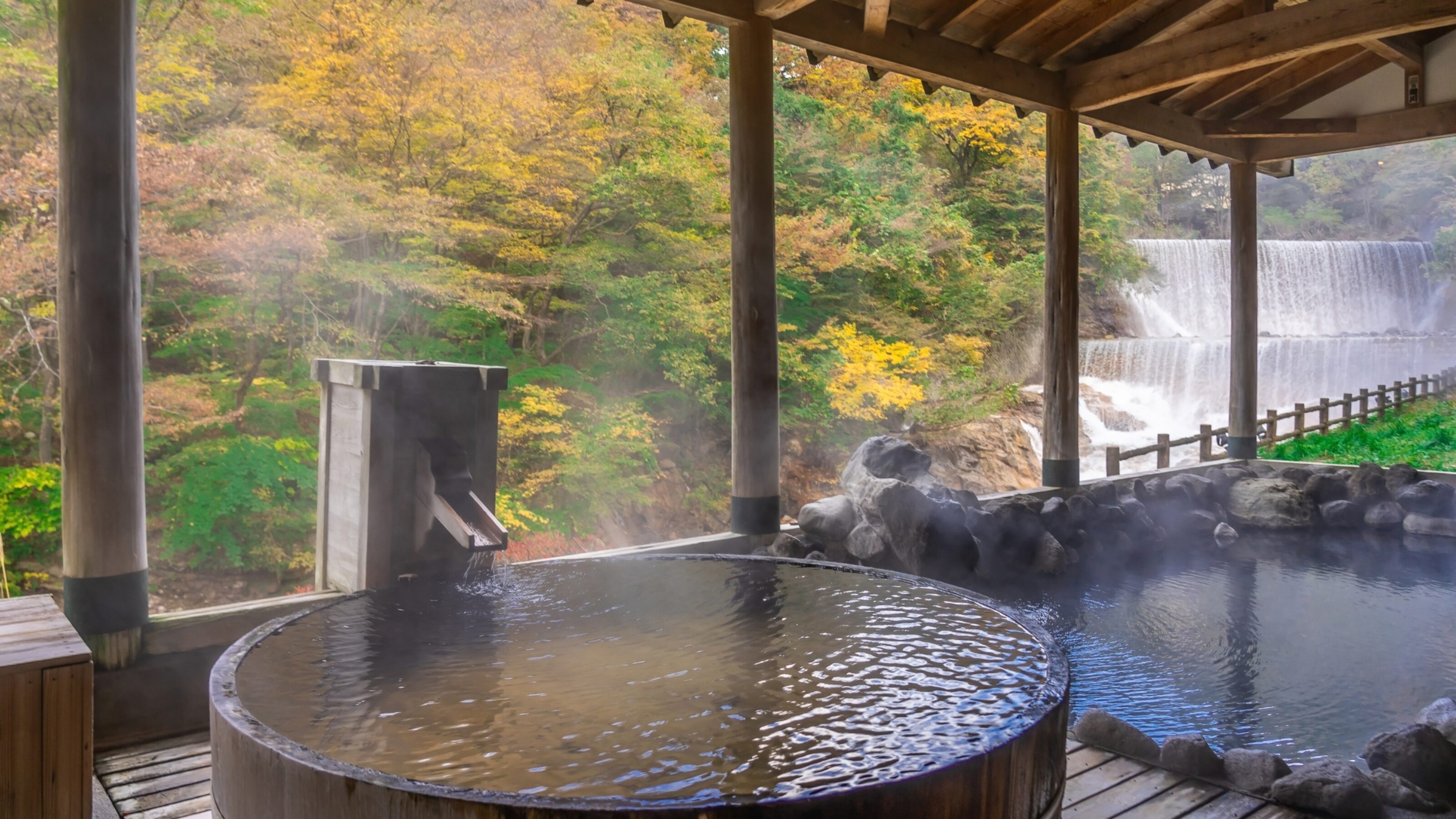 Japanese Hot Springs Onsen Natural Bath Surrounded by red-yellow leaves. In fall leaves fall in Fukushima, Japan.