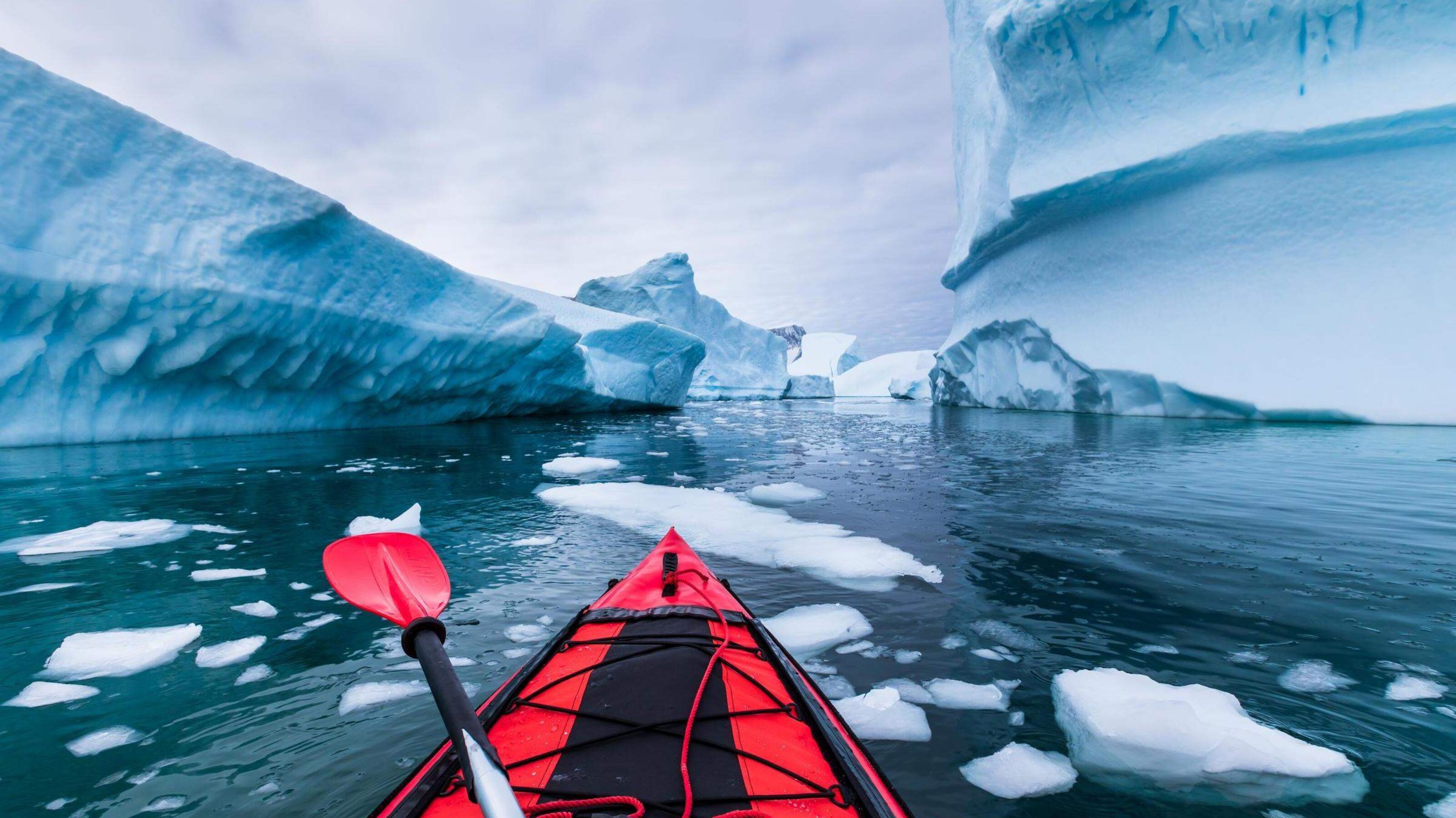 Kayaking in Antarctica between icebergs in an inflatable kayak.