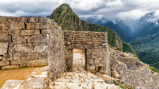 Stone gate at Machu Picchu with Huayna Picchu mountain in the background.
