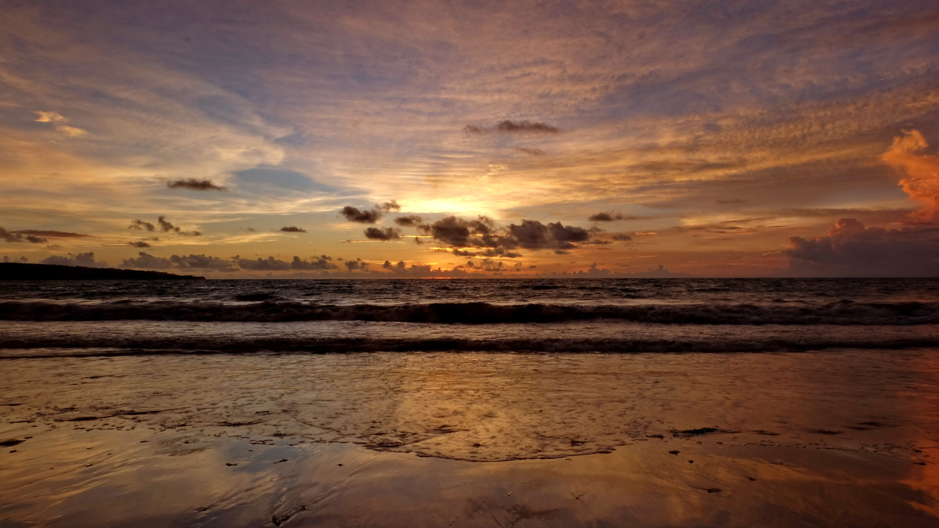 the beauty of Jimbaran beach in Bali Indonesia at dusk with the sun disappearing