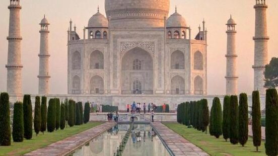 Taj Mahal with reflective water feature in front at dawn.
