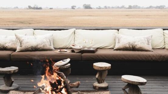 Outdoor seating with a fire pit and a hazy field in the background.