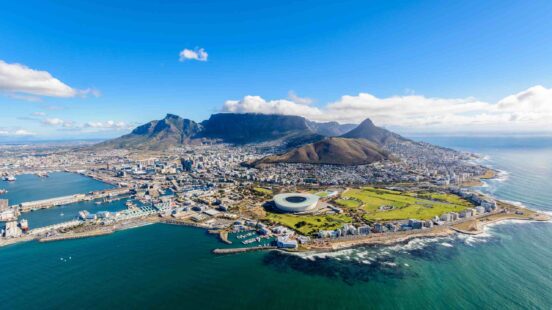 Aerial view of Cape Town with Table Mountain and stadium by the coast.