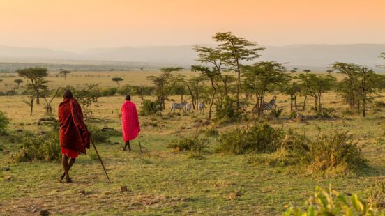 Maasai people walking among the greenery in the Maasai Mara