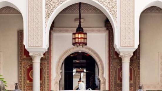 Elegant Moroccan courtyard with arches, intricate patterns, and a central fountain.