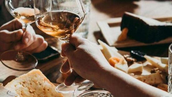 A group of people clinking wine glasses over a table of food