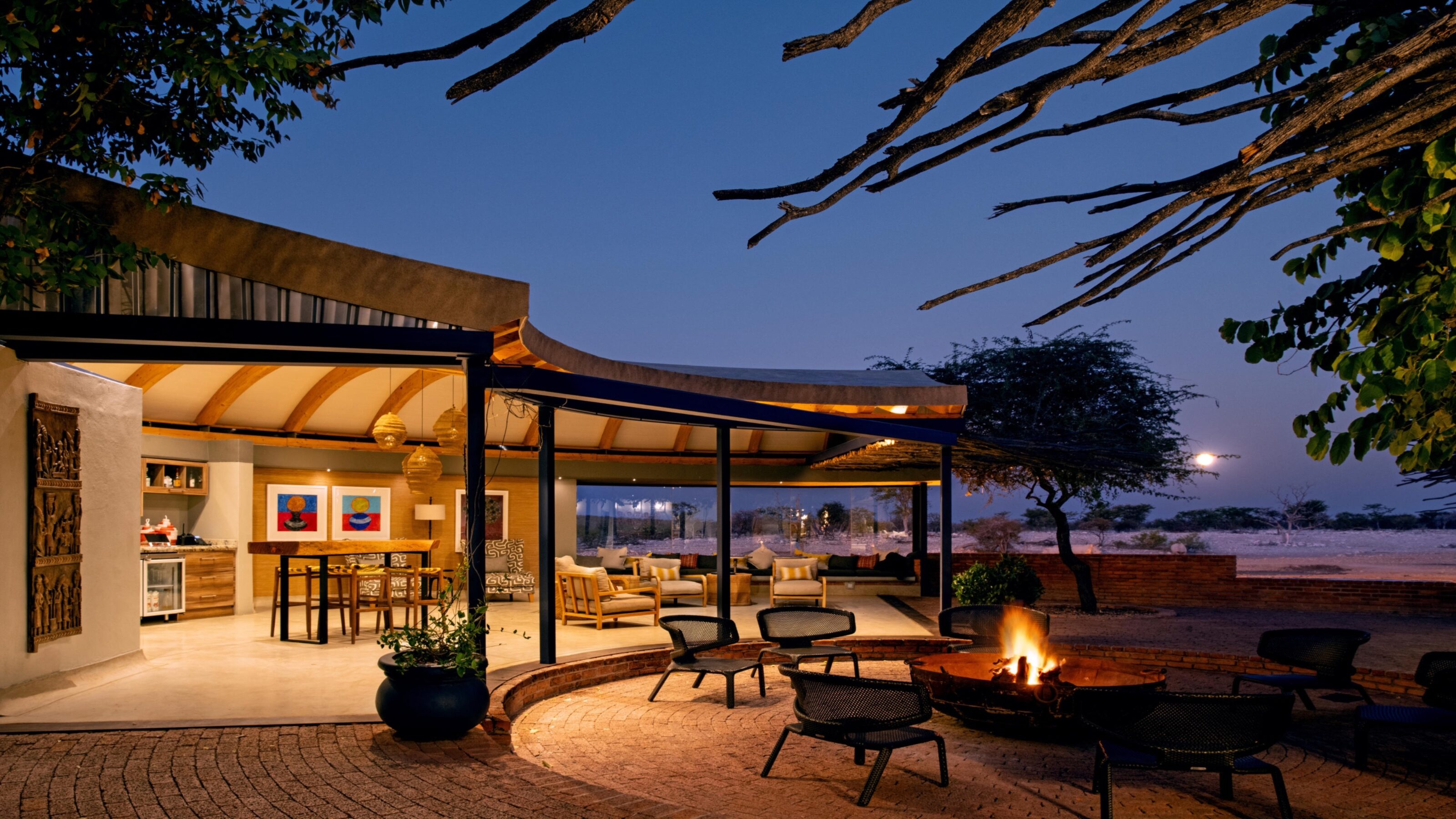 Luxury outdoor patio with a fire pit at twilight, overlooking a serene landscape.