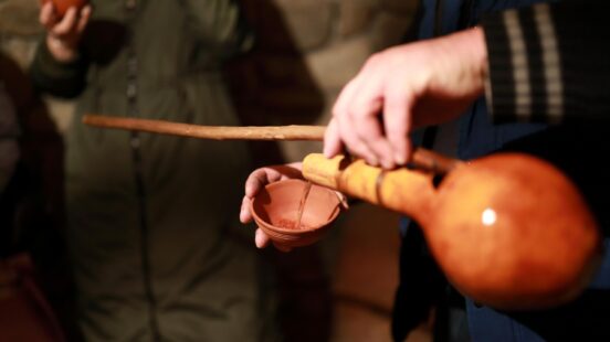 A man pouring wine from a clay jug in Georgia