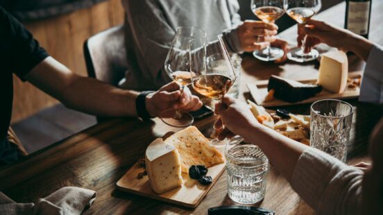 People sat round the table of a wine bar clinking glasses of wine