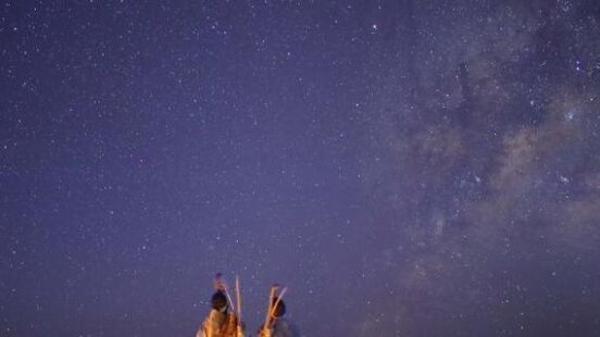 Two people stood side by side watching the stars on the salt pans at Meno a Kwena, Botswana