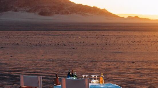 A table and chairs outdoors at sunset at Wilderness Kulala