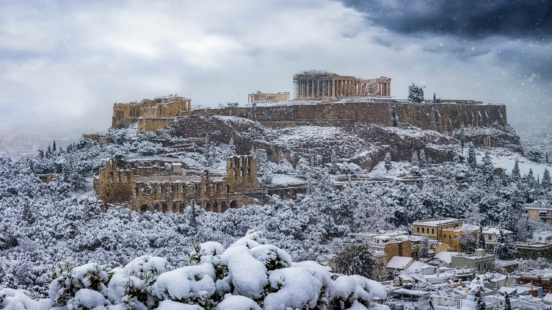 Parthenon Temple at the Acropolis of Athens, Greece, with Skyline and Old Town with Heavy Snowfall in Winter Time