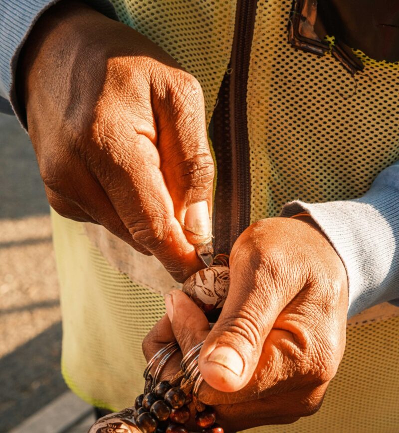 Namibian man carving a makalani palm tree fruit to make a key ring. Makalani key rings are common souvenirs sold all over Namibia.