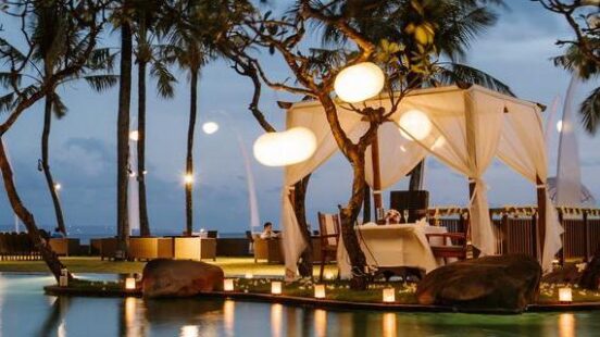 A view of the pool lit up at night time at the Samaya Seminyak