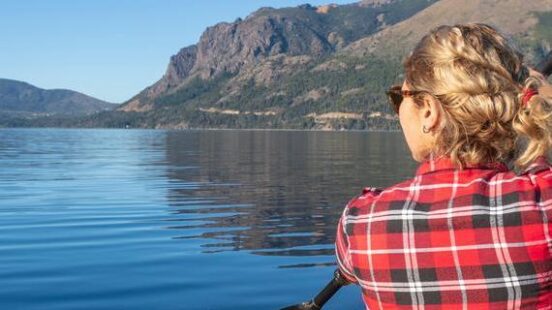 A woman kayaking on a lake in Argentinax27;s Lake District