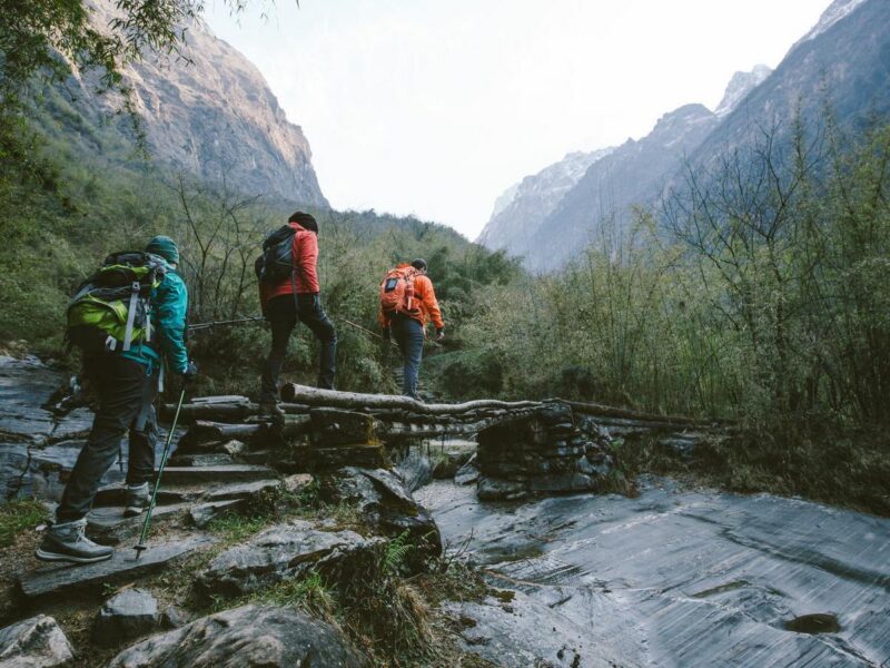 Group of trekkers cross a bridge while hiking
