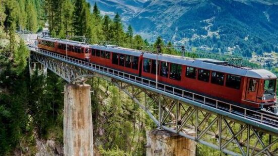 Zermatt, Switzerland. alpine, alps, beautiful, blue, cervino, destination, engine, europe, famous, glacier, gornergrat, gornergratbahn, hiking, ice, journey, landscape, matterhorn, matterhorn panorama, matterhorn summer, mountain, mountaineering, nature, oberland, outdoor, panorama, peak, railway, river, scenery, sky, snow, stone, summer, summit, sunny, swiss, swiss alps, switzerland, tourism, train, travel, travel destination, tree, vacation, valais, water, waterfall, zermatt, zermatt switzerland Zermatt, Switzerland. Gornergrat tourist train with waterfall, bridge and Matterhorn. Valais region.