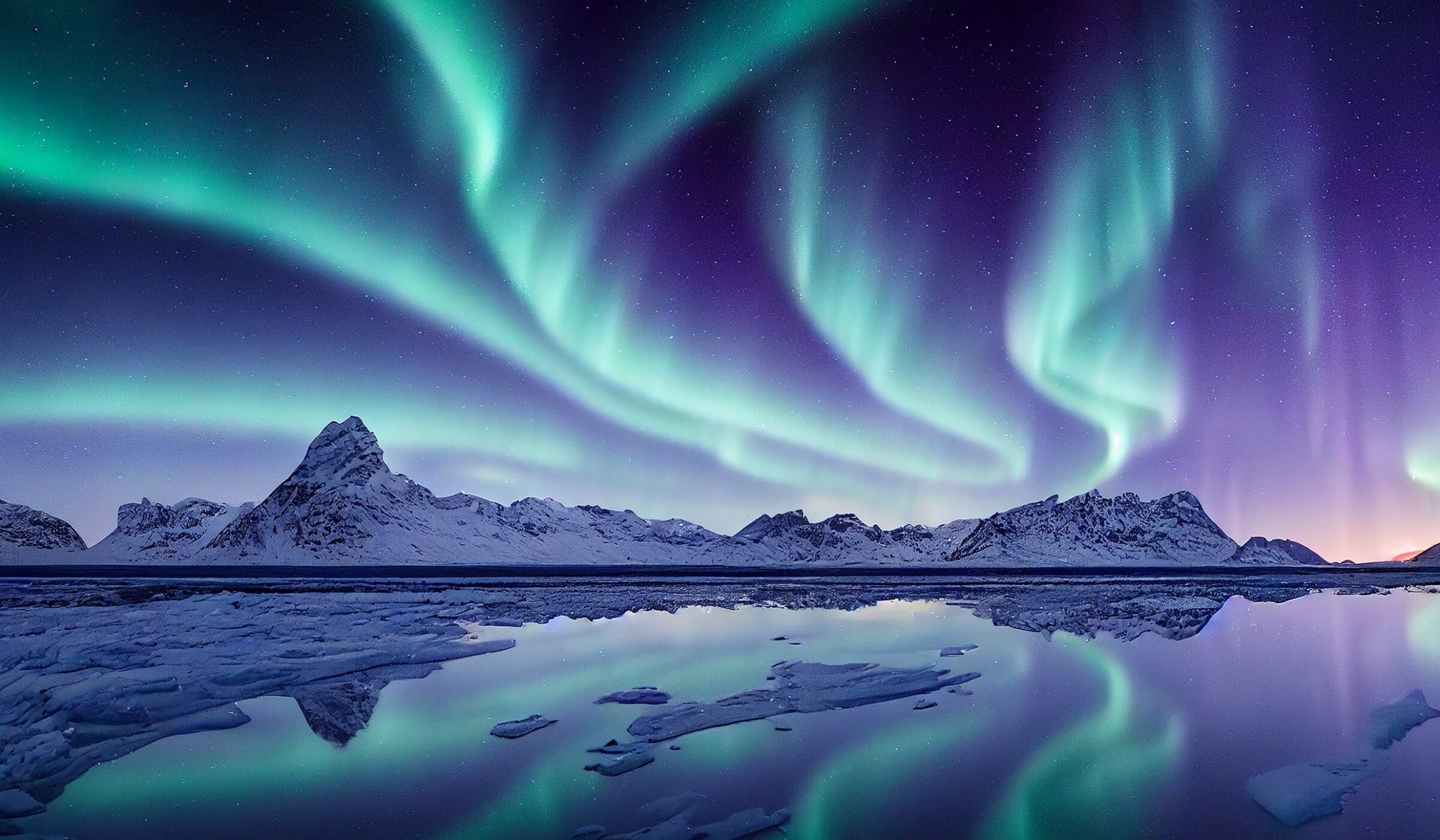 Blue and purple northern lights reflected over a lake