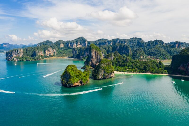 amazing Thailand high season beautiful seascape aerial view ao nang and rairay beach island and long tail and speed boat tourists sailed on the sea water splash foreground krabi province Thailand