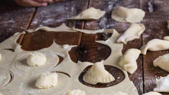 A man making dumplings on a wooden table, the Dolomites