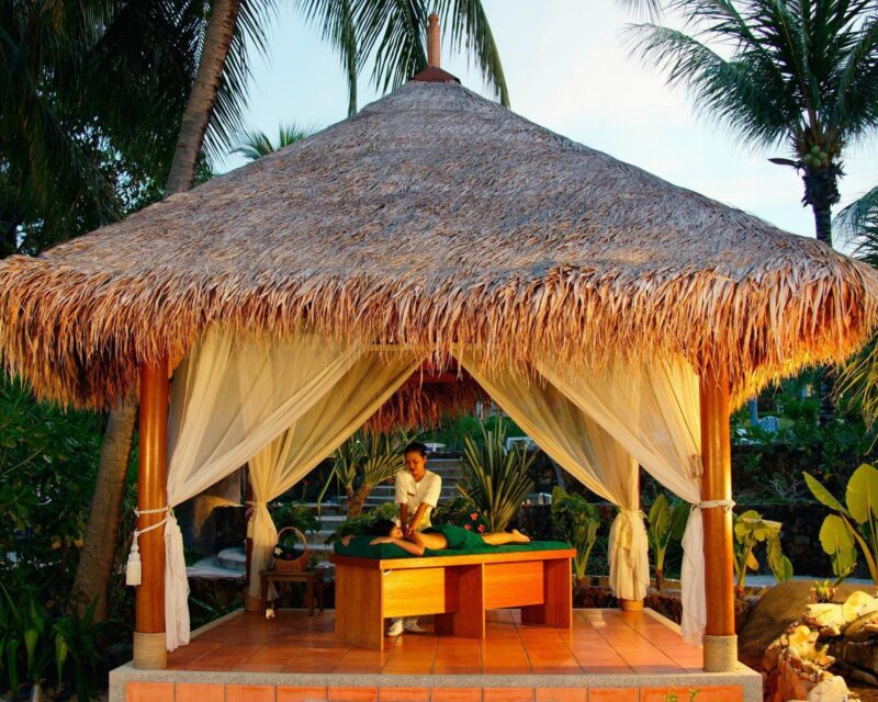 A woman gets a massage in an outdoor spa in Thailand