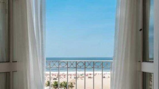 A view of Copacabana beach through the open windows of a room at the Copacabana Palace, Rio de Janeiro, Brazil